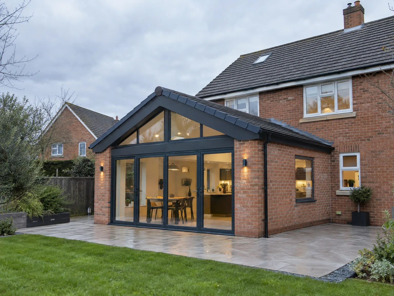 Modern brick rear extension with black framed bifold doors and patio area