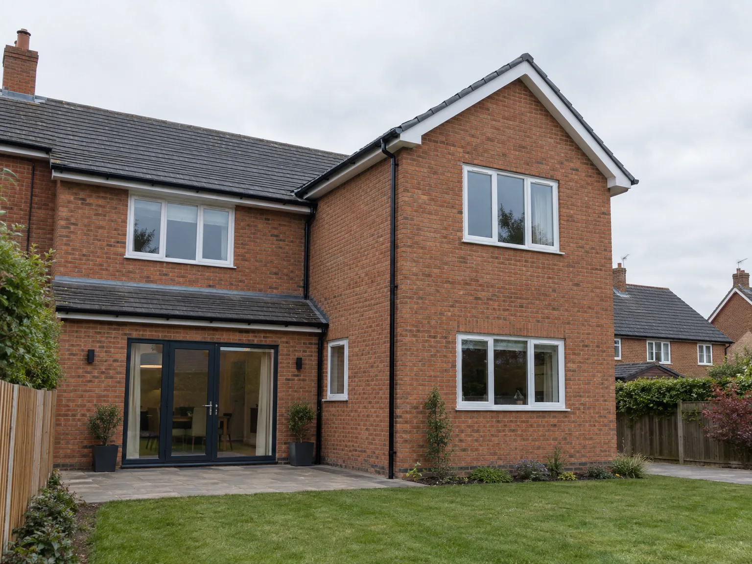 Brick house extension featuring black bifold doors, large windows and garden