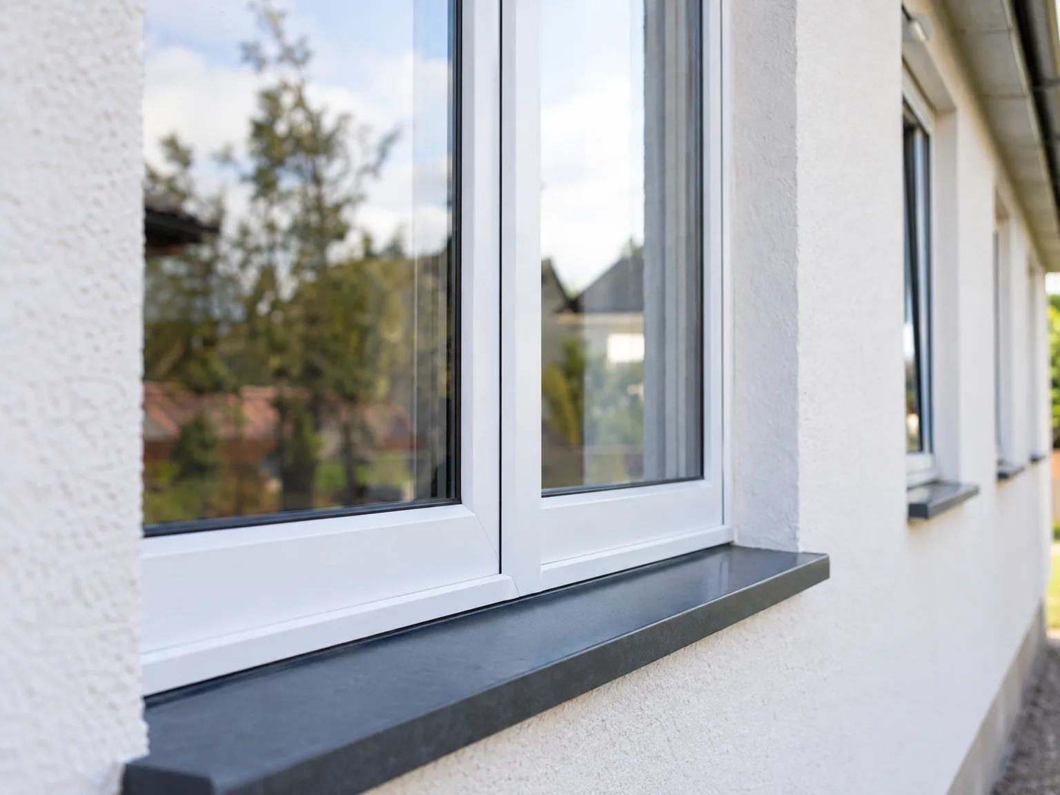 New window installation featuring white frames and black sill on modern facade